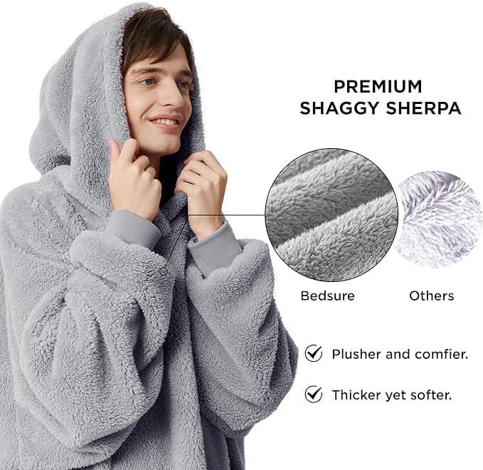 Oversized hoodie blanket with soft fleece fabric, large pockets, and ribbed cuffs for warmth and comfort