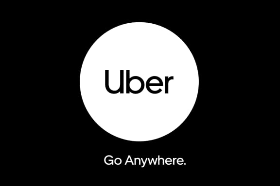 An Uber gift card next to a smartphone showing the Uber app, car keys, and a coffee cup—representing prepaid rides and food delivery convenience. An Uber gift card next to a smartphone showing the Uber app, car keys, and a coffee cup—representing prepaid rides and food delivery convenience.